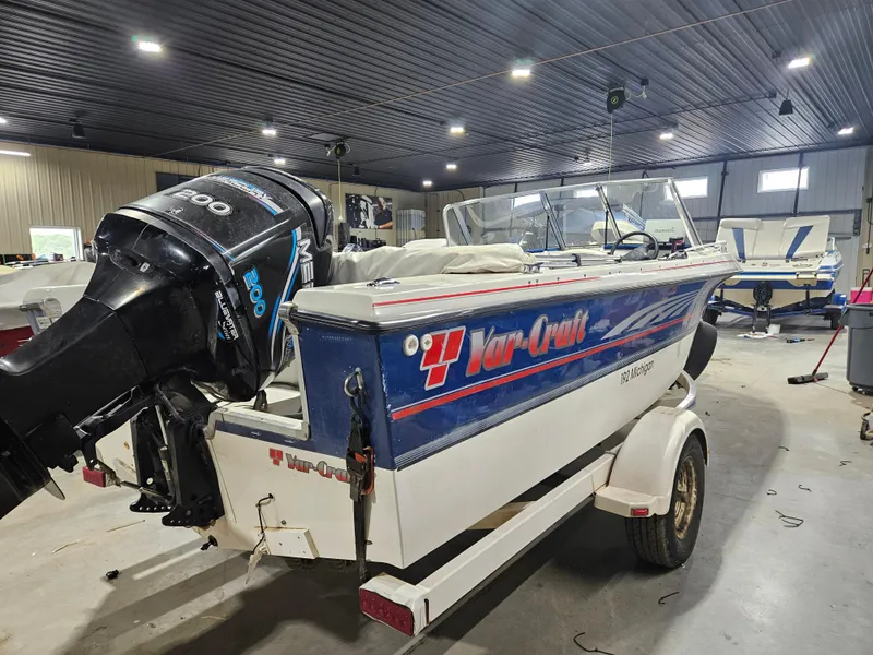 Slide: The Image of 1997 Yar-Craft 192 Michigan boat in a garage, featuring a powerful outboard motor. - 3