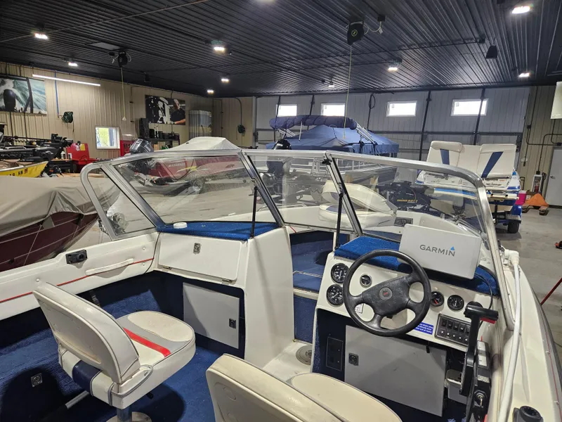 Slide: The Image of 1997 Yar-Craft 192 Michigan boat interior with Garmin navigation, stored in a spacious garage. - 4