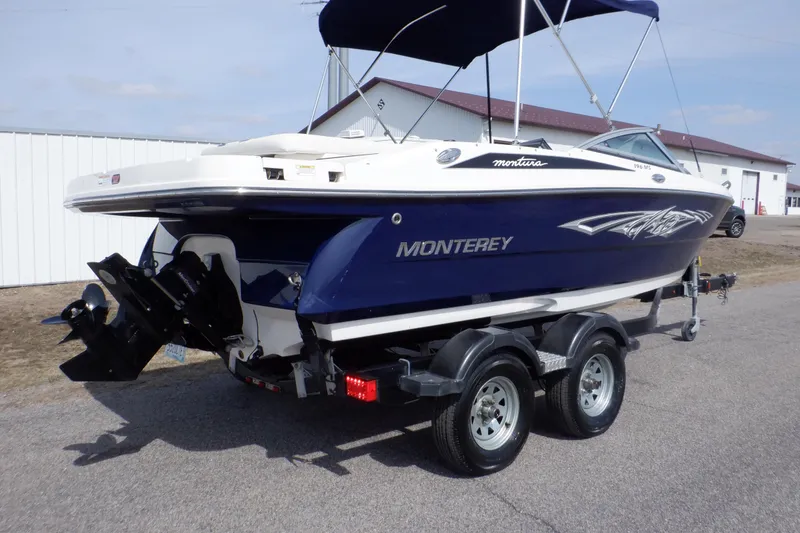 Slide: The Image of 2014 Monterey 196MS boat interior with blue-striped seating and gray deck. - 4