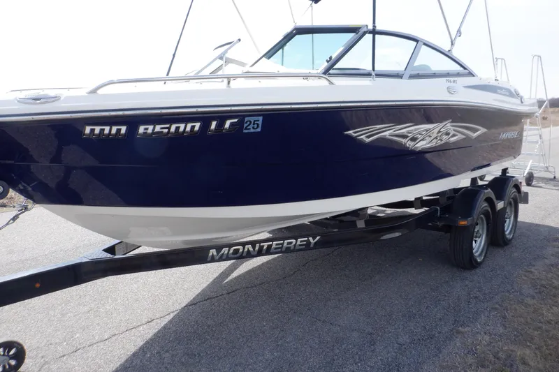 Slide: The Image of 2014 Monterey 196MS boat on trailer, blue and white design, parked outdoors. - 7