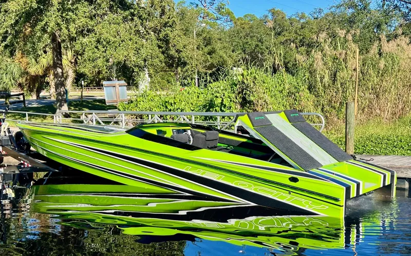 The Image of Bright green 2025 Velocity Raptor speedboat docked on a sunny day. - 1
