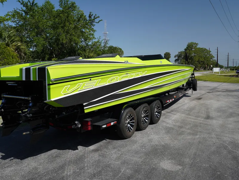 Slide: The Image of 2025 Velocity Raptor speedboat in vibrant green on a trailer, parked outdoors. - 9