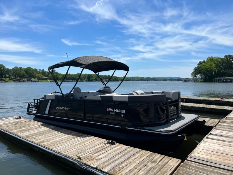 Slide: The Image of 2025 Starcraft SLS 3 pontoon boat docked on a sunny lake. - 2