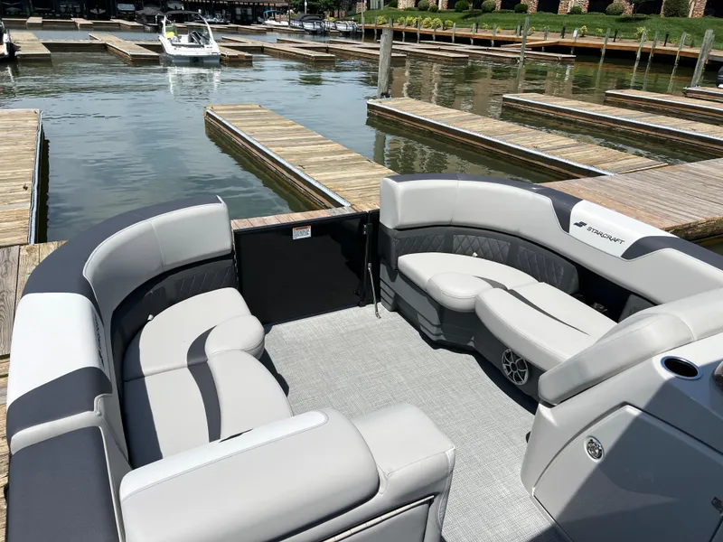 Slide: The Image of 2025 Starcraft SLS 3 pontoon boat with spacious seating at a marina dock. - 4