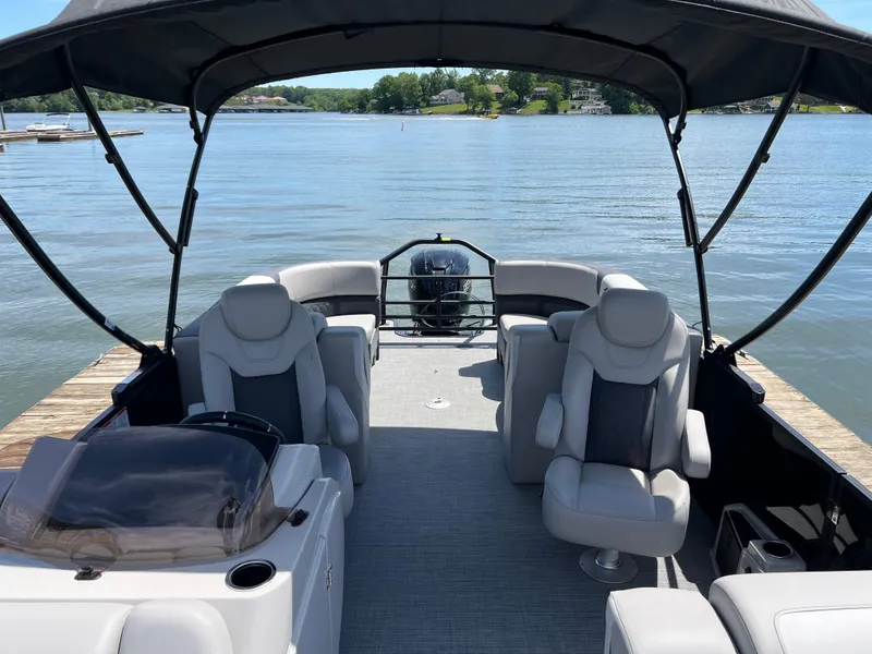 Slide: The Image of 2025 Starcraft SLS 3 pontoon boat interior with plush seating on a serene lake. - 5