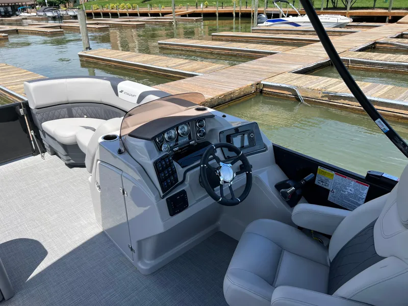 Slide: The Image of 2025 Starcraft SLS 3 boat interior with modern dashboard and comfortable seating at a marina. - 6