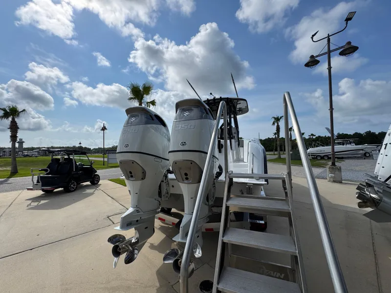 Slide: The Image of 2025 Cape Horn 32 XS boat with dual outboard engines, parked outdoors under a cloudy sky. - 10