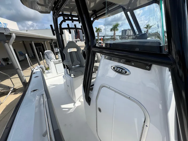 Slide: The Image of 2025 Cape Horn 32 XS boat interior with seating and console, docked under a cloudy sky. - 22
