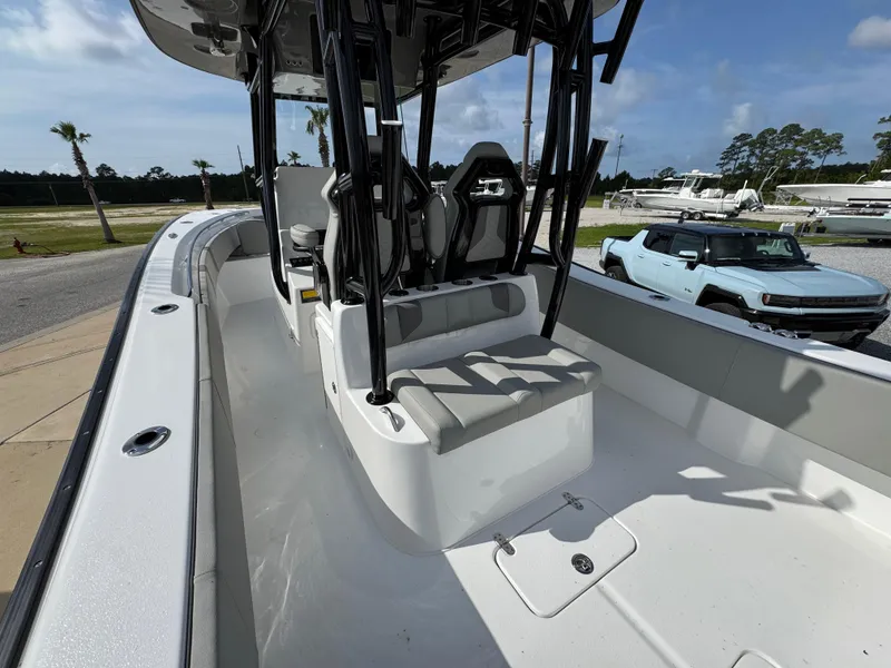 Slide: The Image of 2025 Cape Horn 32 XS boat interior with seating and console, parked near vehicles. - 28