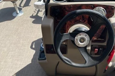 Slide: The Image of 2023 Sun Tracker Bass Buggy 16 XL Select steering console with black wheel and control panel. - 3