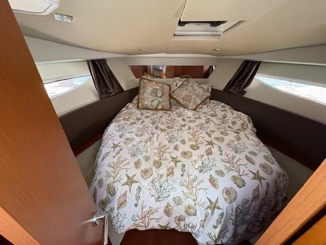 Slide: The Image of 2013 Jeanneau NC11 cabin with nautical-themed bedding and cozy interior. - 12