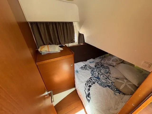 Slide: The Image of Cozy cabin interior of 2013 Jeanneau NC11 with turtle-themed bedding and wooden furnishings. - 13