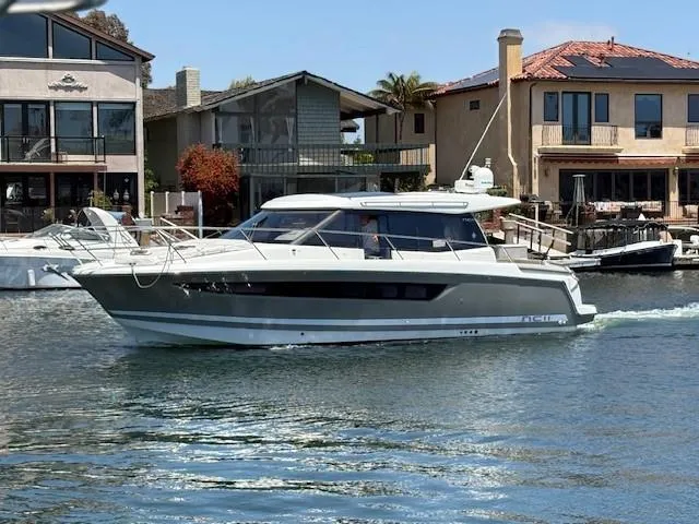 Slide: The Image of 2013 Jeanneau NC11 boat cruising near waterfront homes. - 17