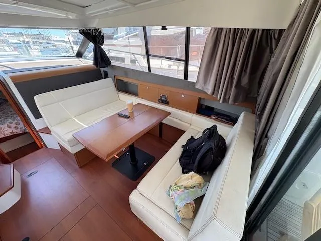 Slide: The Image of Interior of 2013 Jeanneau NC11 yacht with cozy seating and wooden table. - 3