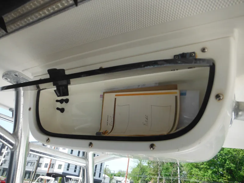 Slide: The Image of 2011 Ranger 2410 Bay Ranger storage compartment with documents inside. - 26