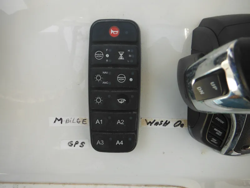 Slide: The Image of Control panel of a 2011 Ranger 2410 Bay Ranger boat with labeled switches and throttle. - 48