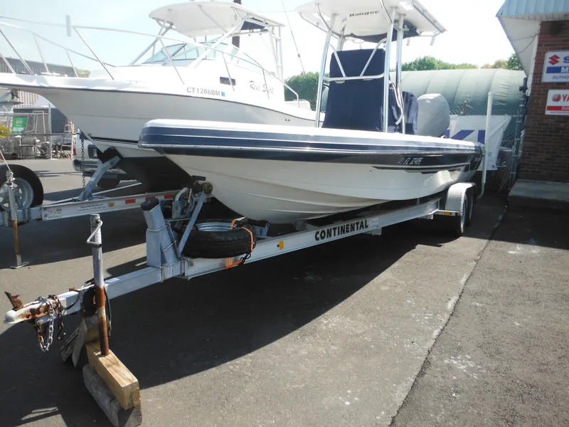 Slide: The Image of 2011 Ranger 2410 Bay Ranger boat on trailer in a marina setting. - 5