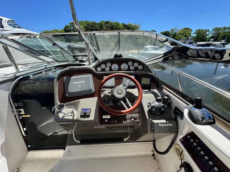Slide: The Image of 2009 Regal Commodore 4060 yacht cockpit with steering wheel and navigation controls. - 14