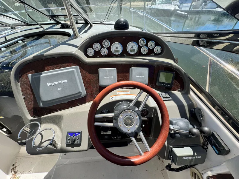 Slide: The Image of 2009 Regal Commodore 4060 helm with Raymarine navigation, wood accents, and ocean view. - 15