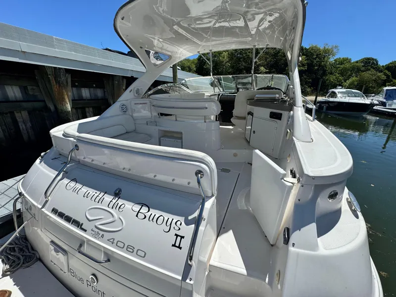 Slide: The Image of 2009 Regal Commodore 4060 yacht cruising near scenic coastal cliffs. - 4