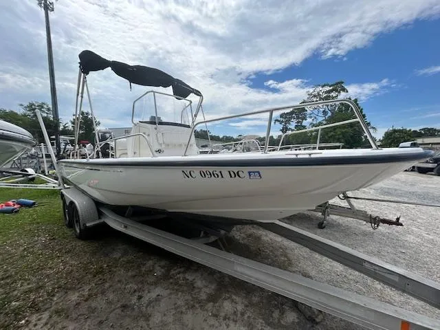The Image of 2005 Boston Whaler 220 Dauntless boat on trailer, parked outdoors under clear blue sky. - 0