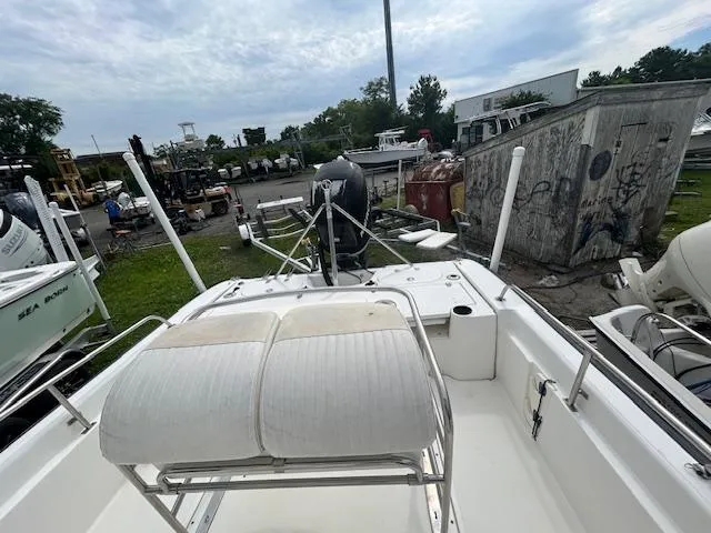 Slide: The Image of 2005 Boston Whaler 220 Dauntless boat interior with seating and motor, docked outdoors. - 11