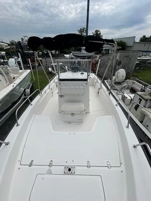 Slide: The Image of 2005 Boston Whaler 220 Dauntless boat, spacious deck, center console, marina setting. - 13