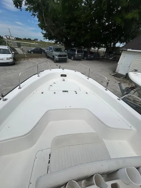 Slide: The Image of 2005 Boston Whaler 220 Dauntless boat, white deck, parked outdoors, surrounded by vehicles. - 14