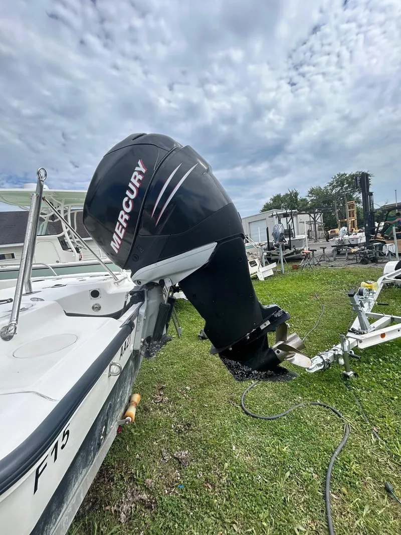 Slide: The Image of 2005 Boston Whaler 220 Dauntless boat on trailer, parked outdoors under cloudy sky. - 4