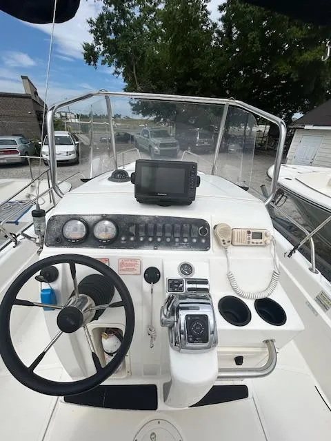 Slide: The Image of 2005 Boston Whaler 220 Dauntless boat on trailer under cloudy sky. - 6