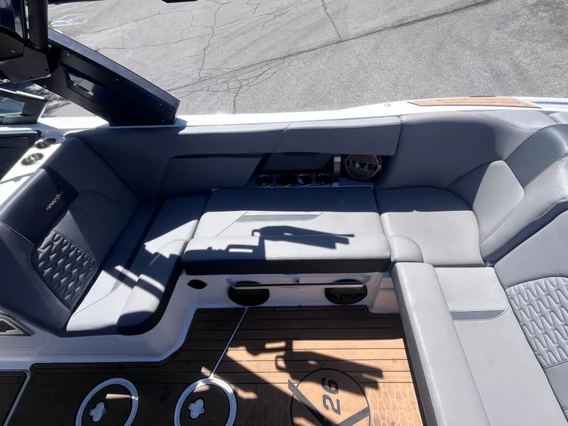 Slide: The Image of 2022 MasterCraft X26 boat interior with gray seating and cup holders. - 10