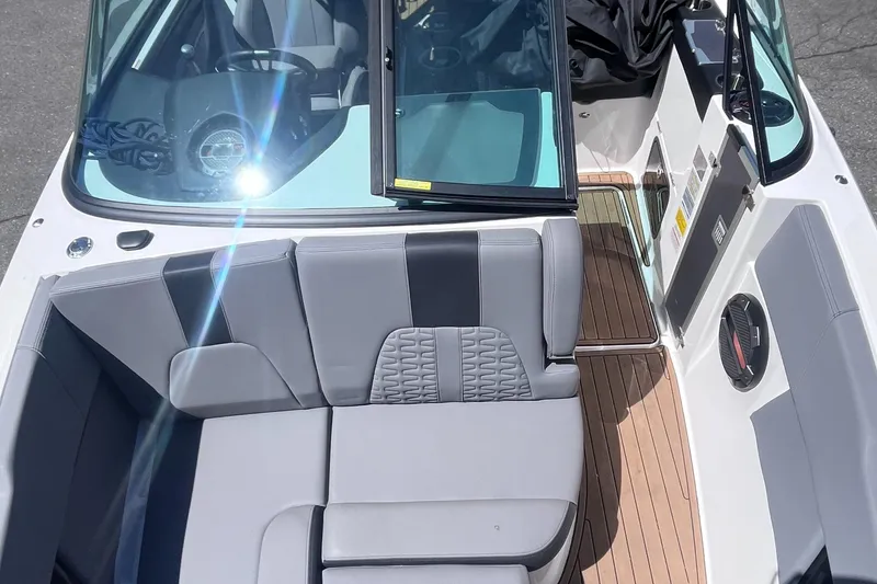 Slide: The Image of 2022 MasterCraft X26 boat interior with gray seating and wooden flooring. - 12