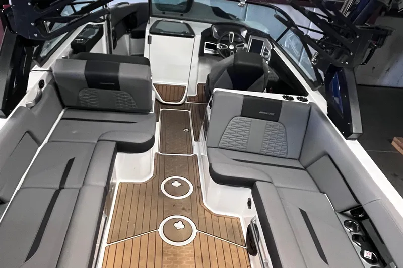Slide: The Image of 2022 MasterCraft X26 boat interior with gray seating and wooden flooring. - 14