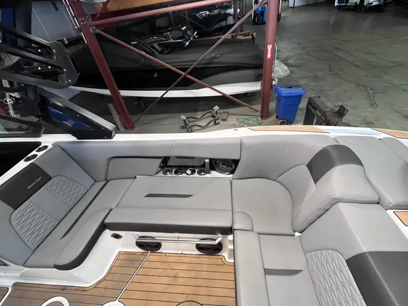 Slide: The Image of 2022 MasterCraft X26 boat interior with gray seating and wood flooring. - 17