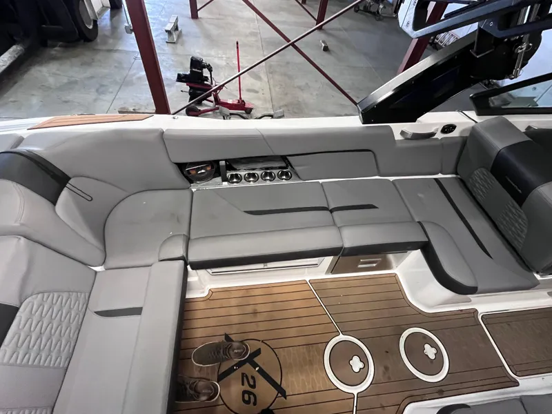 Slide: The Image of 2022 MasterCraft X26 boat interior with gray seating and teak flooring. - 18