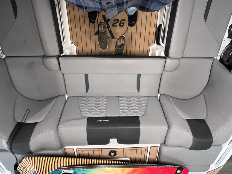 Slide: The Image of 2022 MasterCraft X26 boat interior with gray seating and wooden flooring. - 19