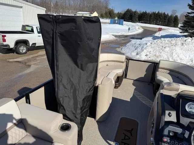 Slide: The Image of 2025 Tahoe Cascade 2385 Versatile Rear Lounger boat with beige seating, parked in snowy area. - 21