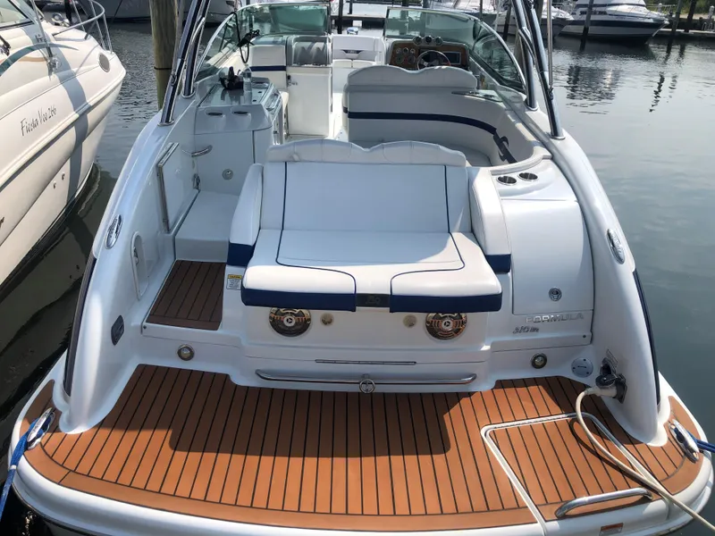 Slide: The Image of 2009 Formula 310 Bowrider I/O boat with spacious seating and teak deck at a marina. - 2