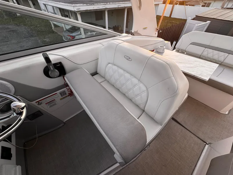Slide: The Image of 2020 Regal 26XO boat interior with white leather seating and steering wheel. - 27