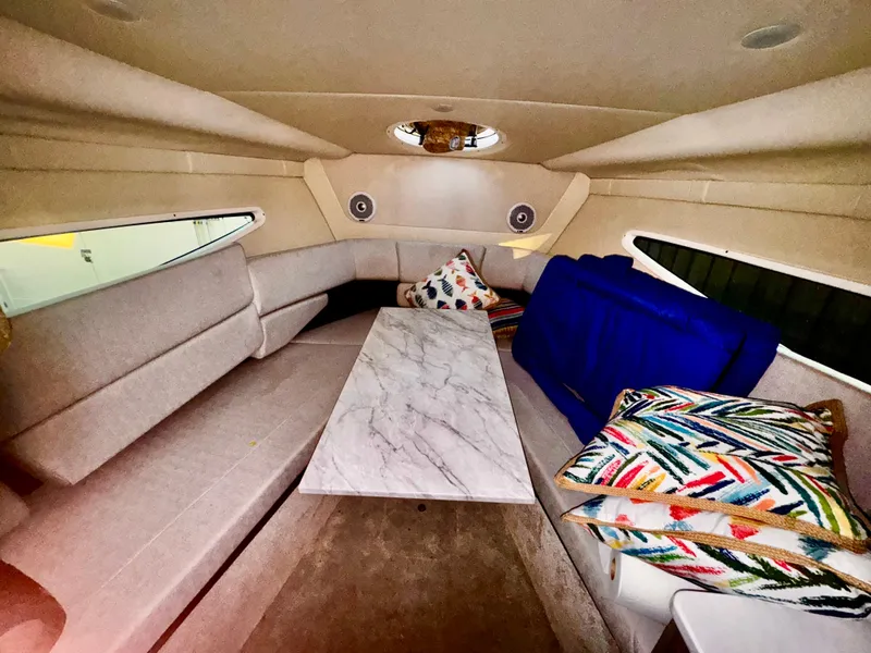 Slide: The Image of 2020 Regal 26XO cabin interior with seating, marble table, and colorful cushions. - 45