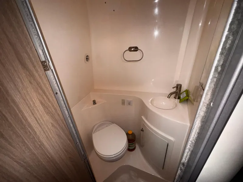 Slide: The Image of Compact bathroom in a 2020 Regal 26XO boat, featuring a toilet and sink. - 48