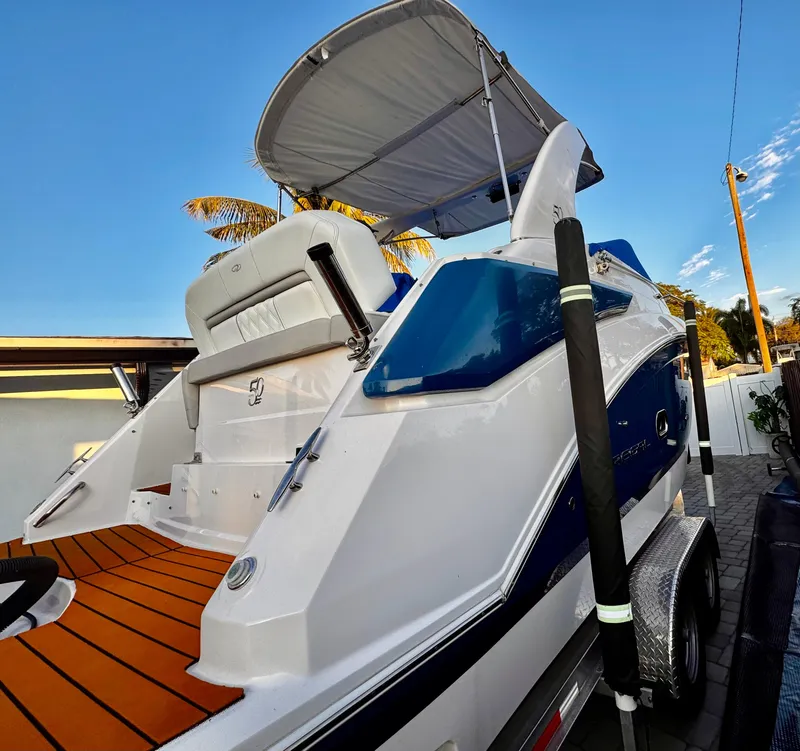 Slide: The Image of 2020 Regal 26XO boat with canopy, docked on trailer, under clear blue sky. - 7