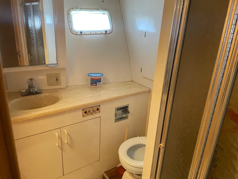 Slide: The Image of 1988 Hatteras 55 Convertible yacht bathroom with sink, toilet, and shower. - 17