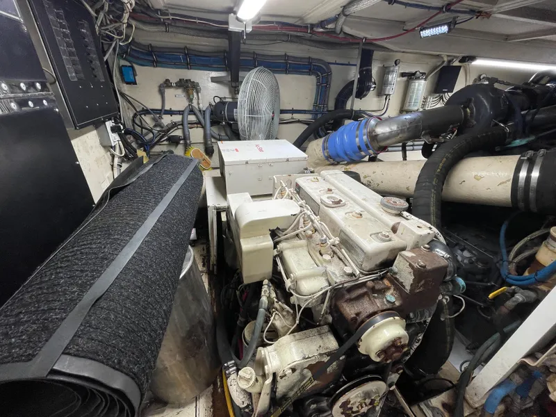 Slide: The Image of Engine room of a 1988 Hatteras 55 Convertible yacht, showcasing machinery and equipment. - 20