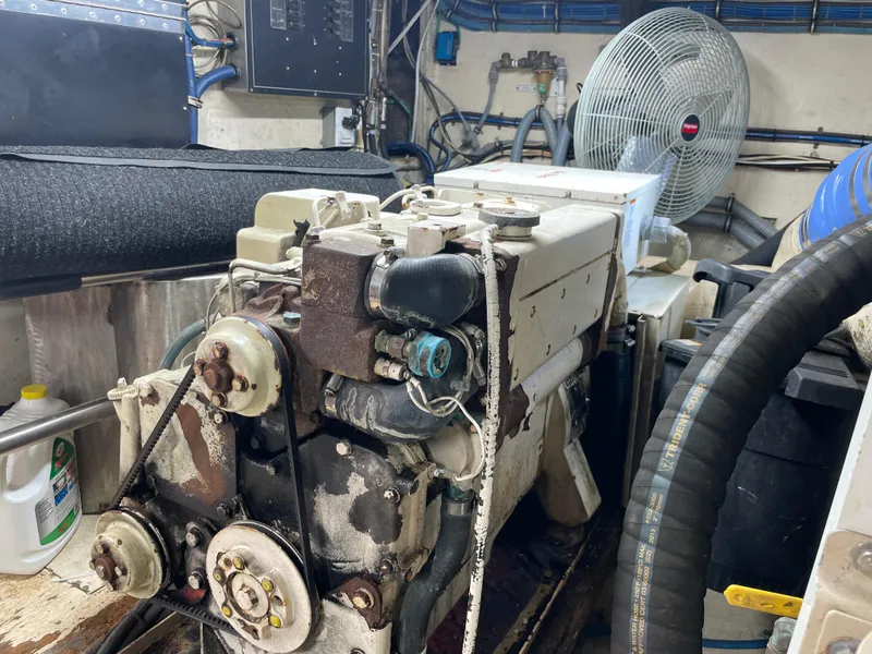 Slide: The Image of Engine room of 1988 Hatteras 55 Convertible yacht, featuring machinery and ventilation fan. - 22