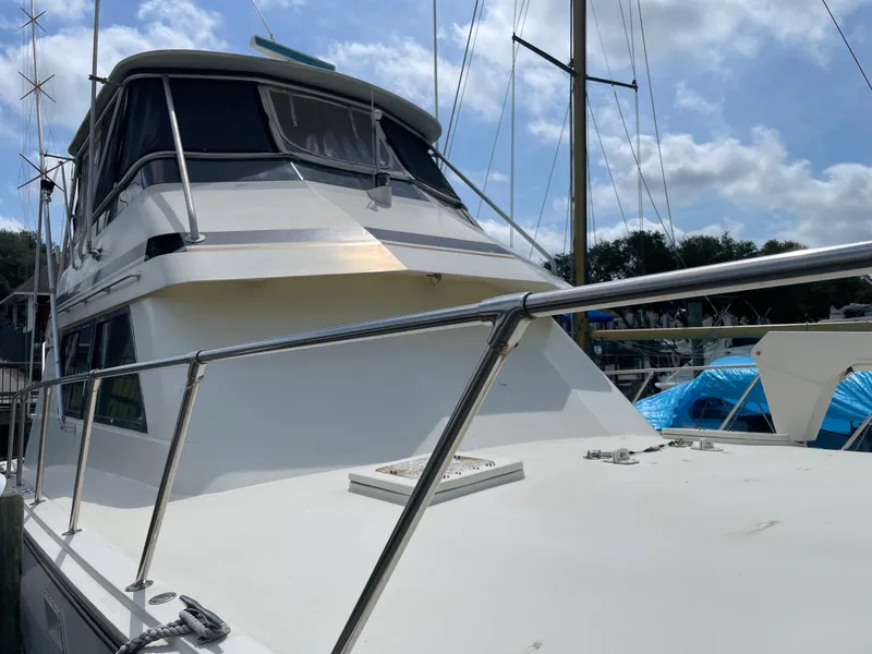 Slide: The Image of 1988 Hatteras 55 Convertible yacht docked under a partly cloudy sky. - 3