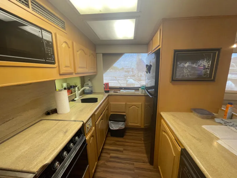 Slide: The Image of 1988 Hatteras 55 Convertible yacht kitchen with wood cabinets and modern appliances. - 30