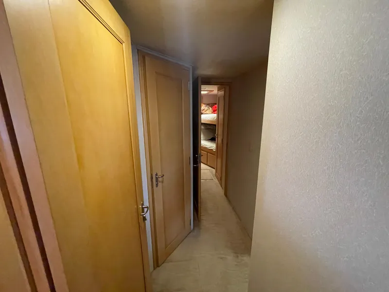 Slide: The Image of Narrow hallway inside 1988 Hatteras 55 Convertible yacht with wooden doors and carpeted floor. - 32