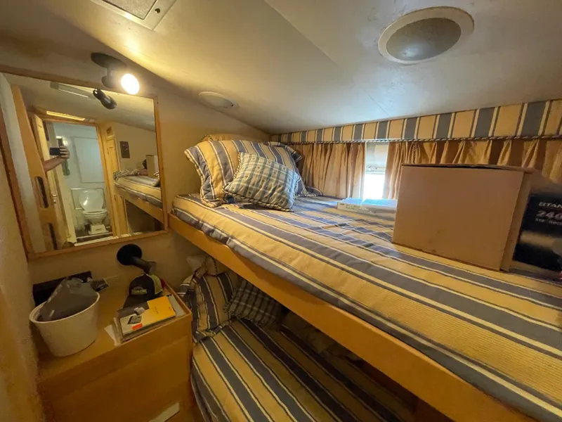 Slide: The Image of Cozy cabin interior of 1988 Hatteras 55 Convertible with striped bedding and mirror. - 34