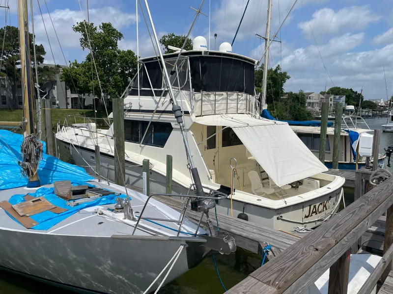 Slide: The Image of 1988 Hatteras 55 Convertible yacht docked at marina under blue sky. - 4